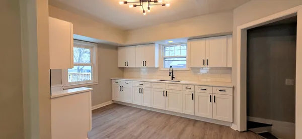 a kitchen with granite countertop white cabinets and white appliances