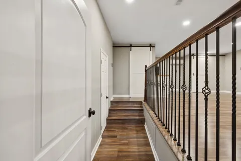 a view of a hallway with wooden floor and staircase