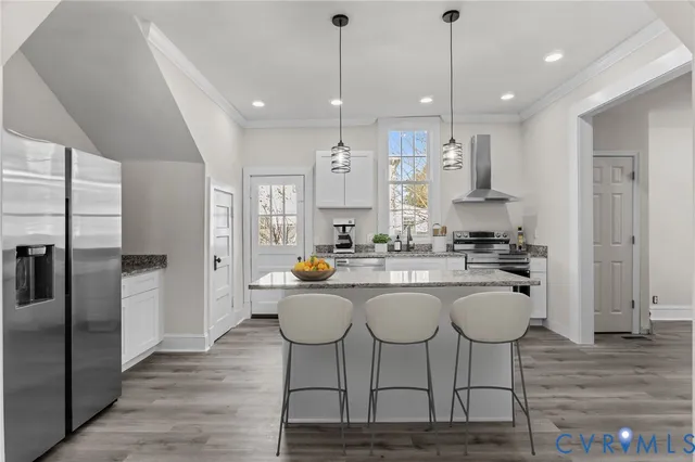 a kitchen with stainless steel appliances granite countertop a refrigerator a sink dishwasher a dining table and chairs with wooden floor