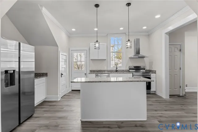 a large kitchen with stainless steel appliances kitchen island granite countertop a large counter top a stove a sink and a refrigerator