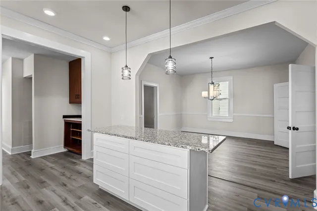 a view of a kitchen island a chandelier and wooden floor