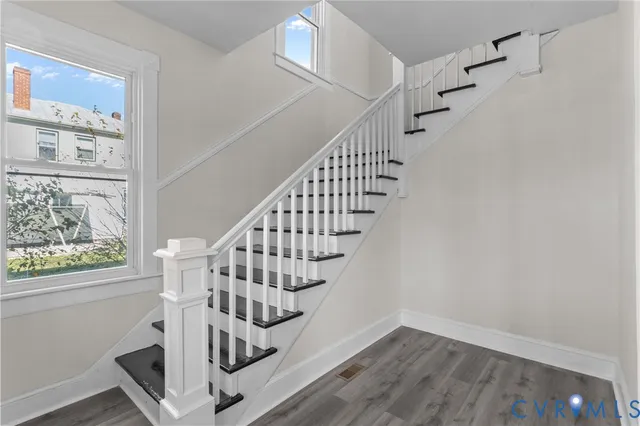 a view of entryway with wooden floor and front door