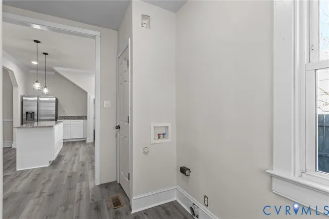 a view of a hallway with wooden floor and a bathroom