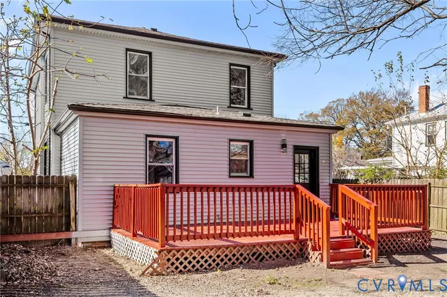 a view of a house with a yard and wooden fence