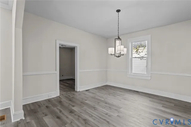 a view of a room with wooden floor ceiling fan and windows