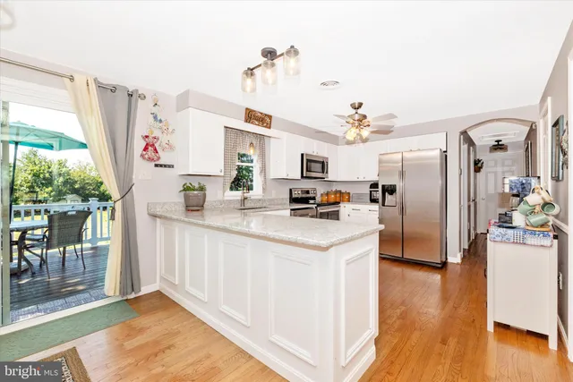 a kitchen with stainless steel appliances kitchen island granite countertop a refrigerator and a sink