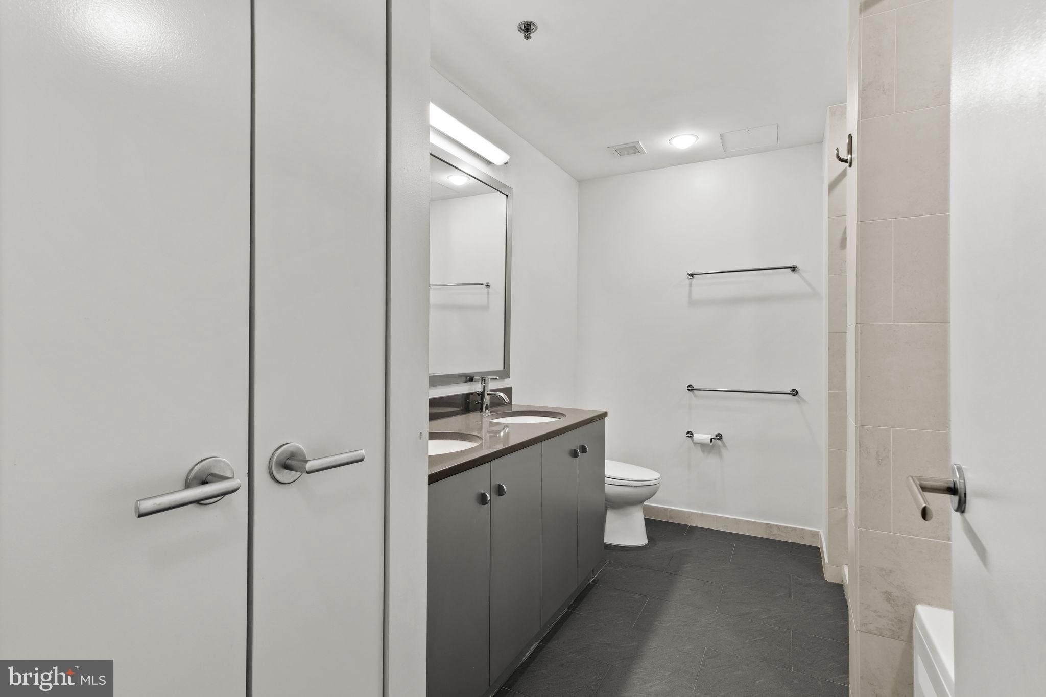 2101 Market Street, Unit 2007 Philadelphia, PA 19103 - Photo 28 of 45 a bathroom with a toilet a sink and mirror