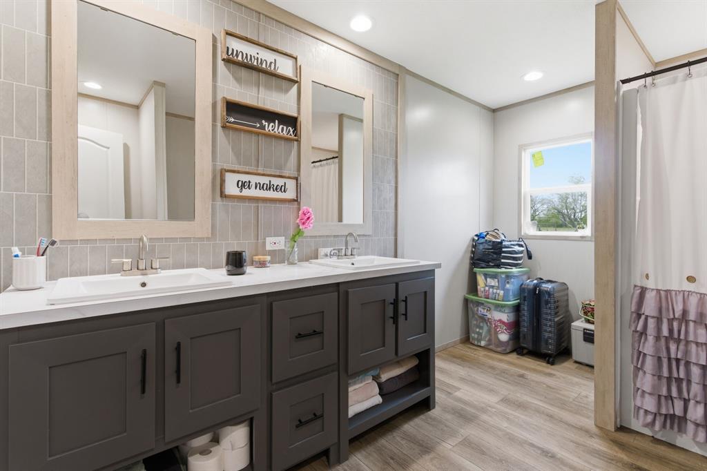 8792 Highway 67 Saltillo, TX 75478 - Photo 23 of 40 a bathroom with a double vanity sink and a mirror