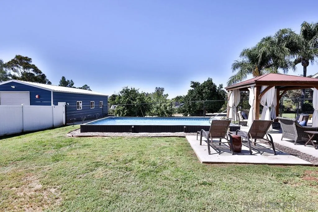 1305 Ashley Road Ramona, CA 92065 - Photo 44 of 72 a view of a patio with table and chairs potted plants with wooden floor and fence