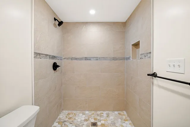 a bathroom with a shower toilet and sink