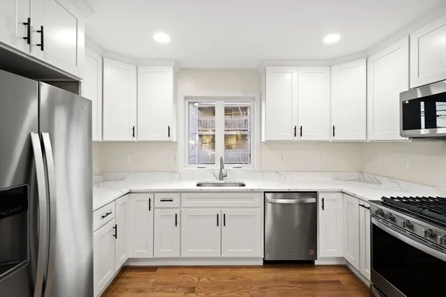 a kitchen with white cabinets stainless steel appliances and sink
