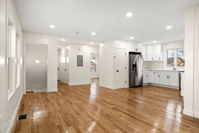 a view of a kitchen with refrigerator and white cabinets