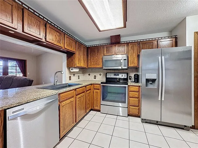 a kitchen with stainless steel appliances granite countertop a refrigerator sink and cabinets