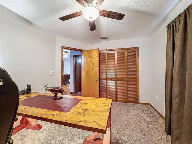 a bedroom with a bed dresser and a large window