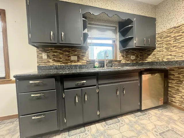 a kitchen with granite countertop cabinets stainless steel appliances and a sink