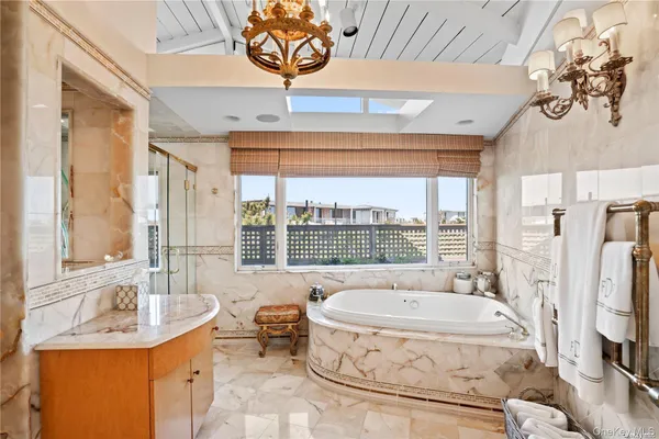 a spacious bathroom with a tub sink and mirror