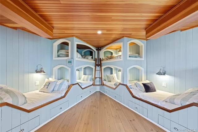 a view of living room kitchen with stainless steel appliances wooden floor and chandelier
