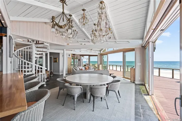 a dining room with wooden floor a chandelier a wooden table and chairs
