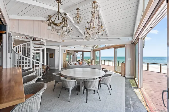 a dining room with wooden floor a chandelier a wooden table and chairs