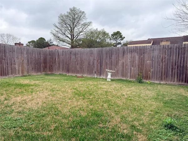 a view of garden with wooden fence