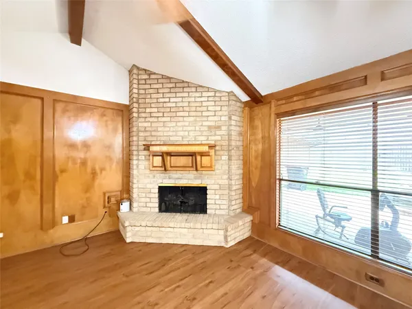 a view of an empty room with a fireplace and a window