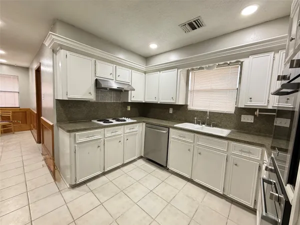 a kitchen with granite countertop white cabinets and white appliances