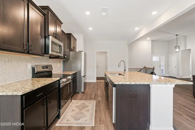 a kitchen with stainless steel appliances granite countertop a sink stove and cabinets