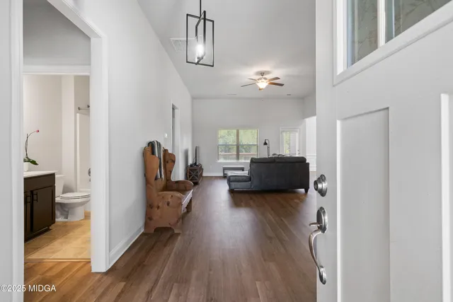a view of a livingroom with furniture a ceiling fan and wooden floor