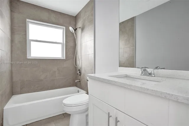 a bathroom with a granite countertop toilet a sink and bathtub