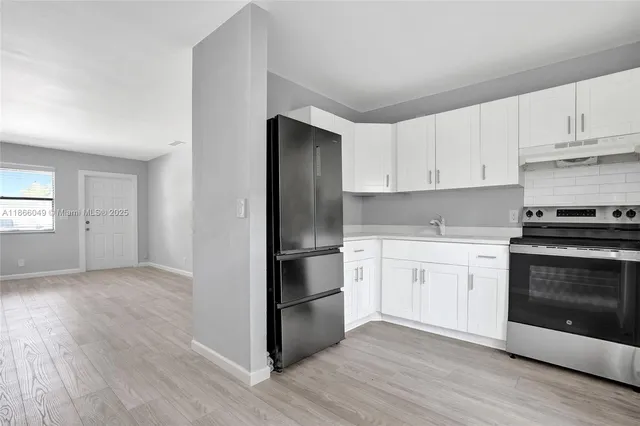 a kitchen with a refrigerator stove and white cabinets