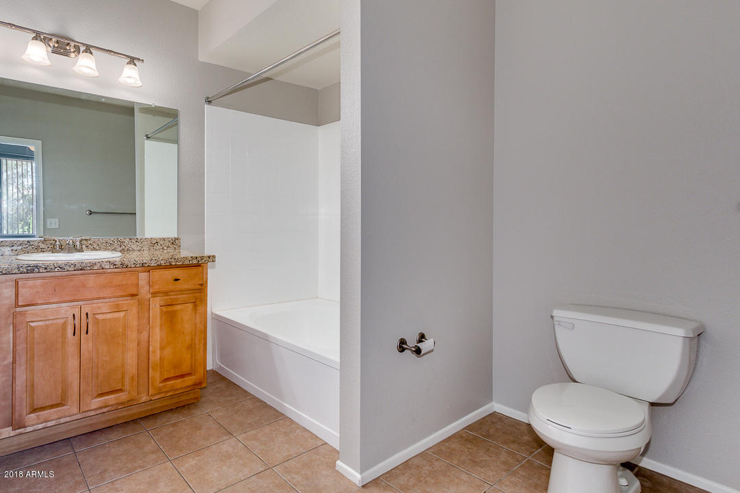 16013 South Desert Foothills Parkway, Unit 2090 Phoenix, AZ 85048 - Photo 22 of 43 a bathroom with a granite countertop toilet sink and mirror