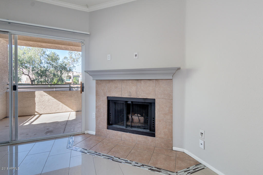 16013 South Desert Foothills Parkway, Unit 2090 Phoenix, AZ 85048 - Photo 6 of 43 a living room with a fireplace and a floor to ceiling window