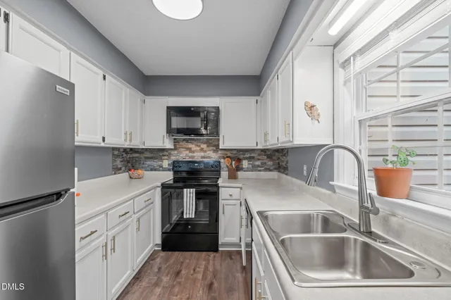 a kitchen with a sink cabinets a counter top space and stainless steel appliances