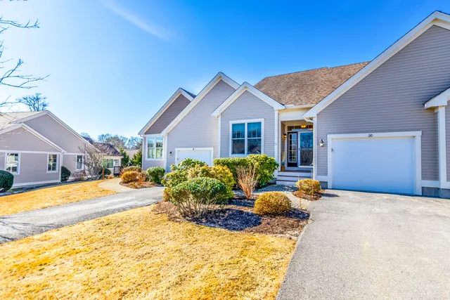 a view of a house with a yard and potted plants