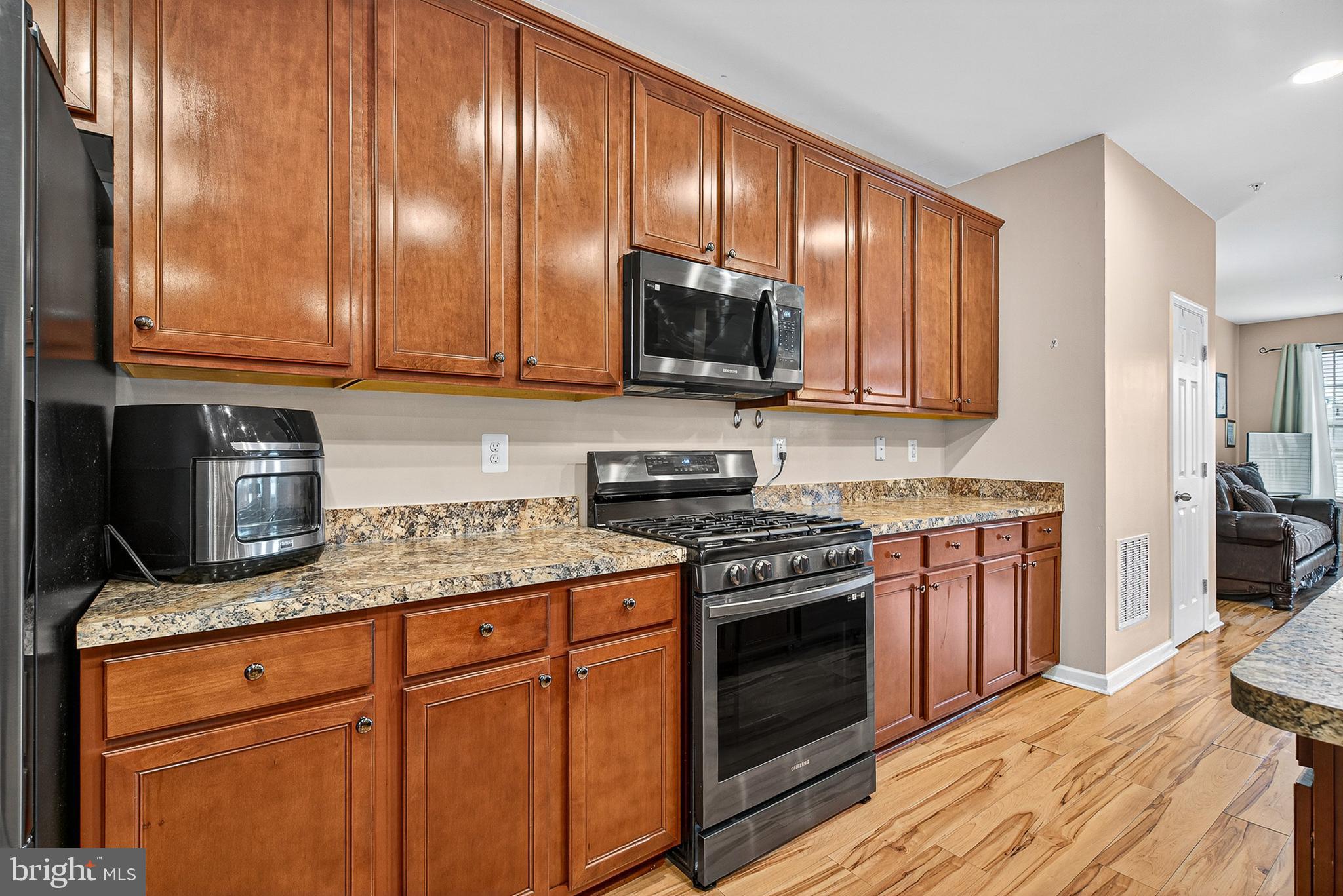 671 English Ivy Way Aberdeen, MD 21001 - Photo 6 of 30 a kitchen with granite countertop wooden cabinets and a stove top oven