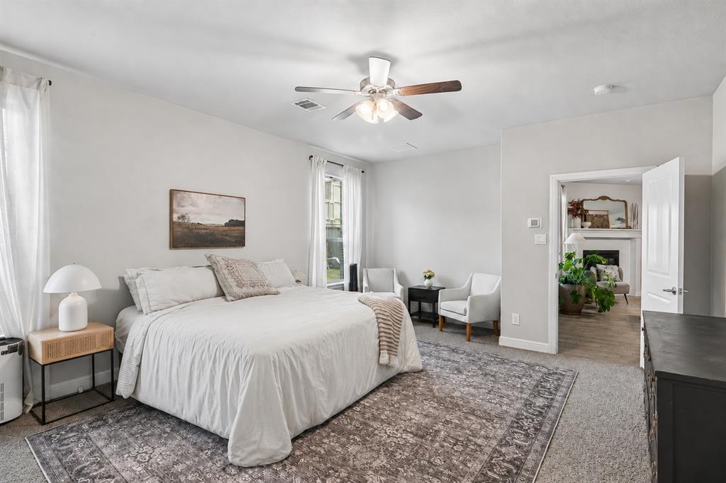 1306 Trailblazer Way Northlake, TX 76247 - Photo 15 of 40 Spacious bedroom featuring light gray walls, carpet flooring, a ceiling fan with light fixture, and two windows providing ample natural light