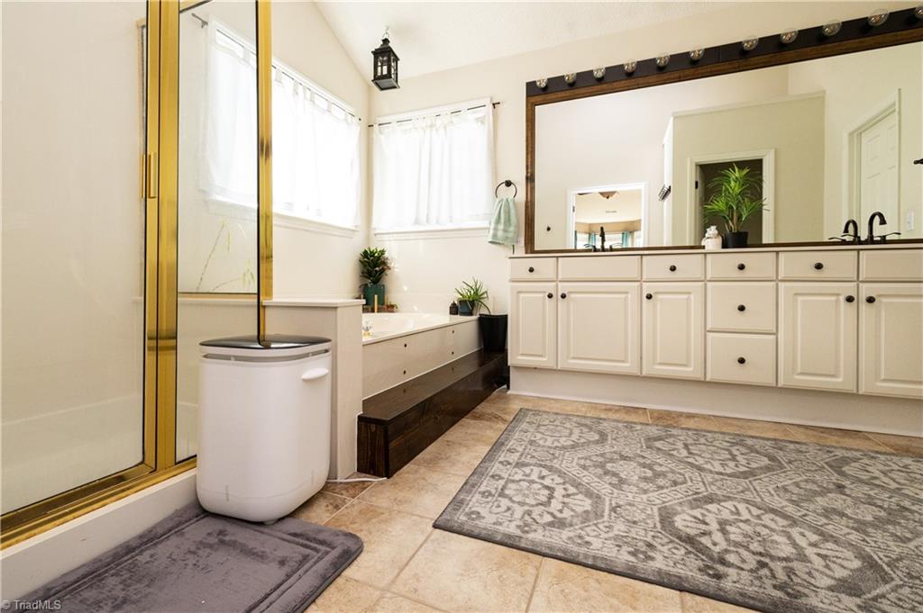 1403 Spring Tree Court High Point, NC 27265 - Photo 21 of 35 En suite bathroom with double vanities and stand alone shower and bathtub.