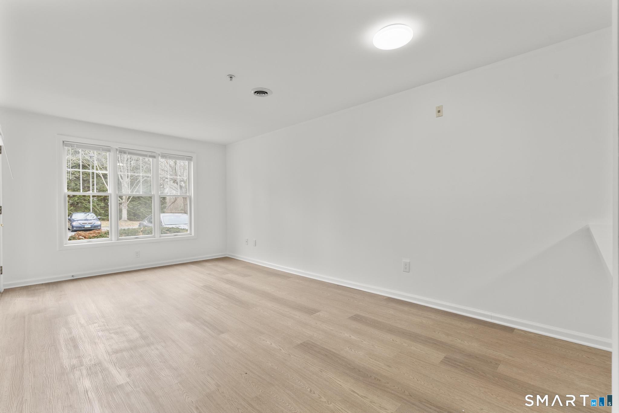 468 Main Street, Unit 111 East Lyme, CT 06357 - Photo 24 of 37 wooden floor in an empty room with a window