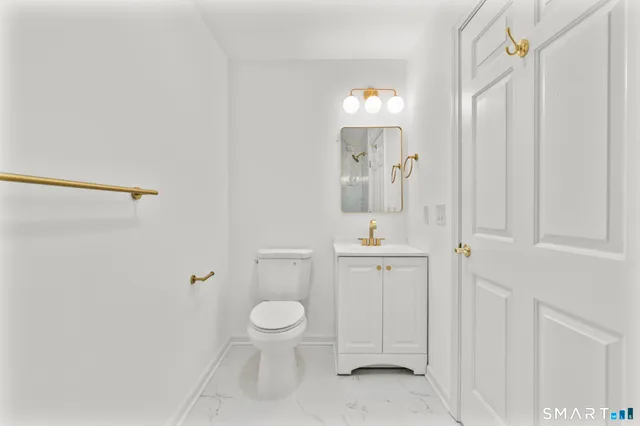 a bathroom with a toilet a sink and mirror