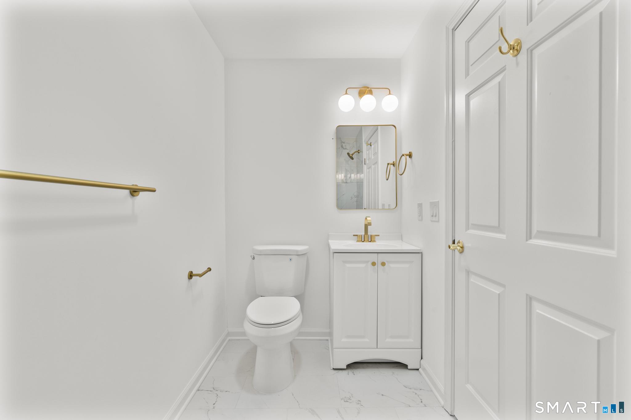 468 Main Street, Unit 111 East Lyme, CT 06357 - Photo 27 of 37 a bathroom with a toilet a sink and mirror