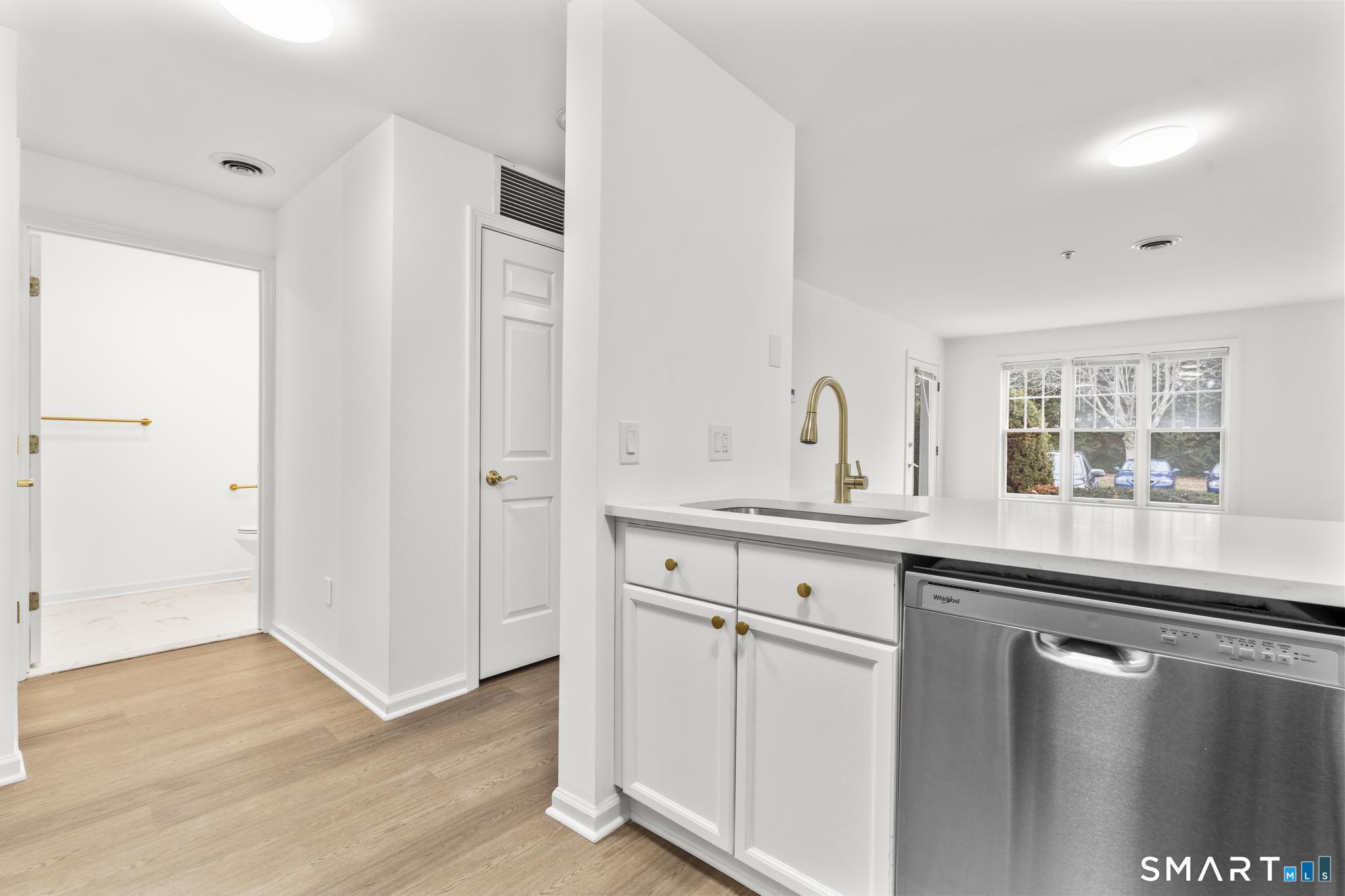 468 Main Street, Unit 111 East Lyme, CT 06357 - Photo 32 of 37 a kitchen with stainless steel appliances granite countertop a sink and cabinets with wooden floor