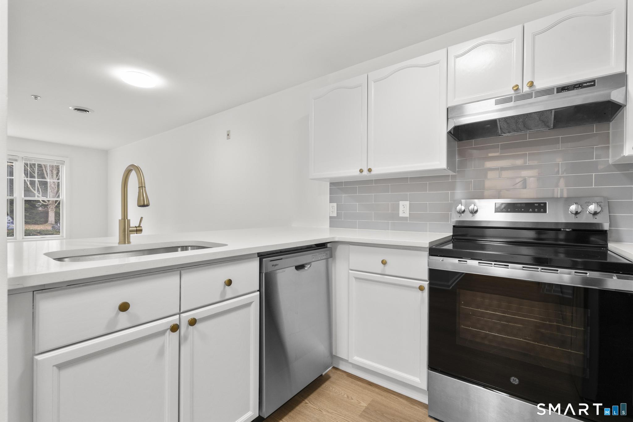 468 Main Street, Unit 111 East Lyme, CT 06357 - Photo 33 of 37 a kitchen with granite countertop white cabinets and appliances