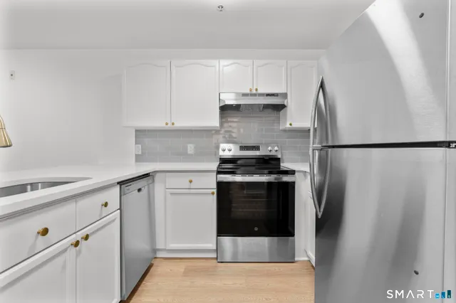 a kitchen with stainless steel appliances a refrigerator stove and cabinets