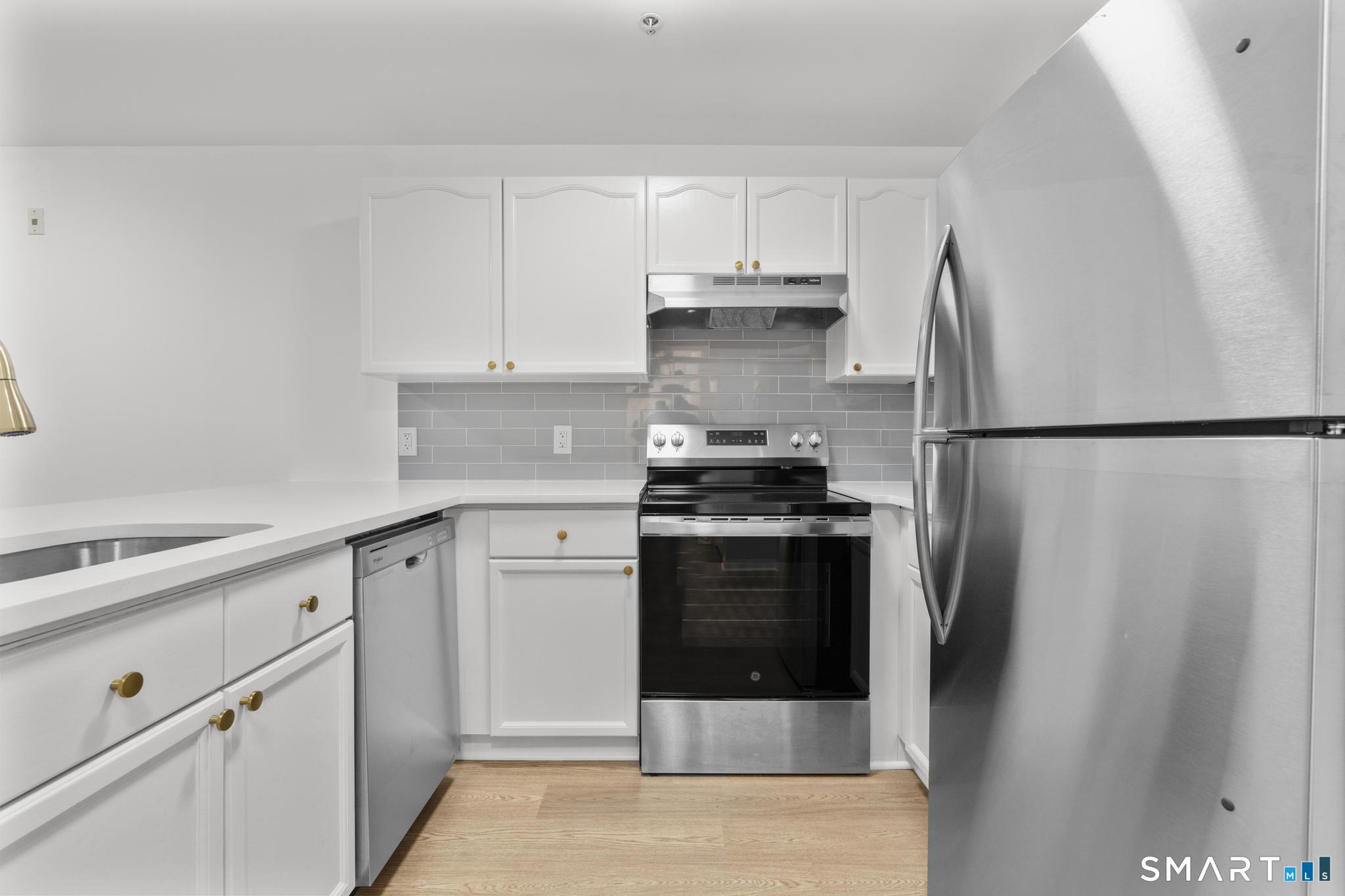 468 Main Street, Unit 111 East Lyme, CT 06357 - Photo 34 of 37 a kitchen with stainless steel appliances a refrigerator stove and cabinets
