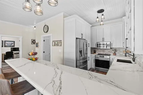 a kitchen with stainless steel appliances kitchen island granite countertop a refrigerator and a stove
