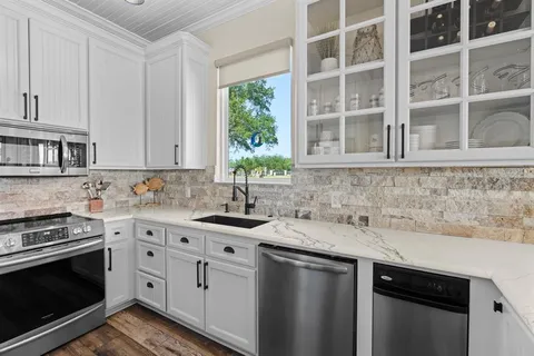 a kitchen with stainless steel appliances granite countertop a sink stove and cabinets