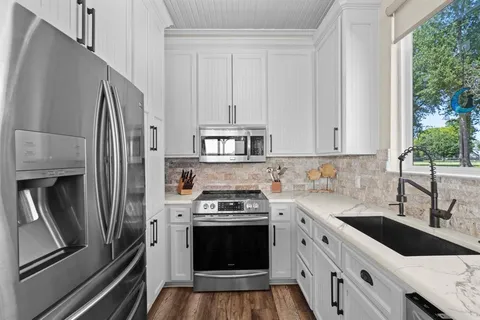 a kitchen with stainless steel appliances a stove a sink and a refrigerator
