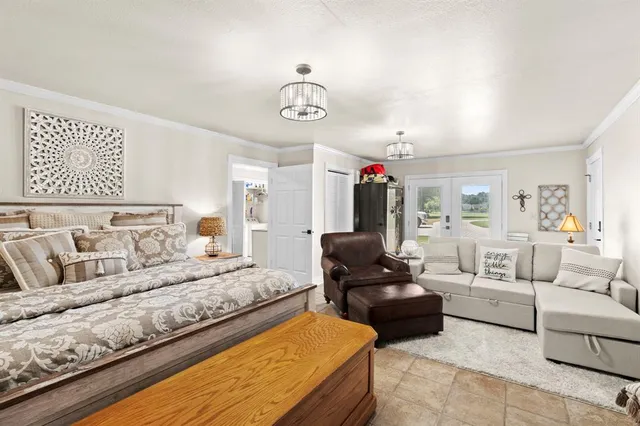 a spacious bedroom with a bed mirror and couch