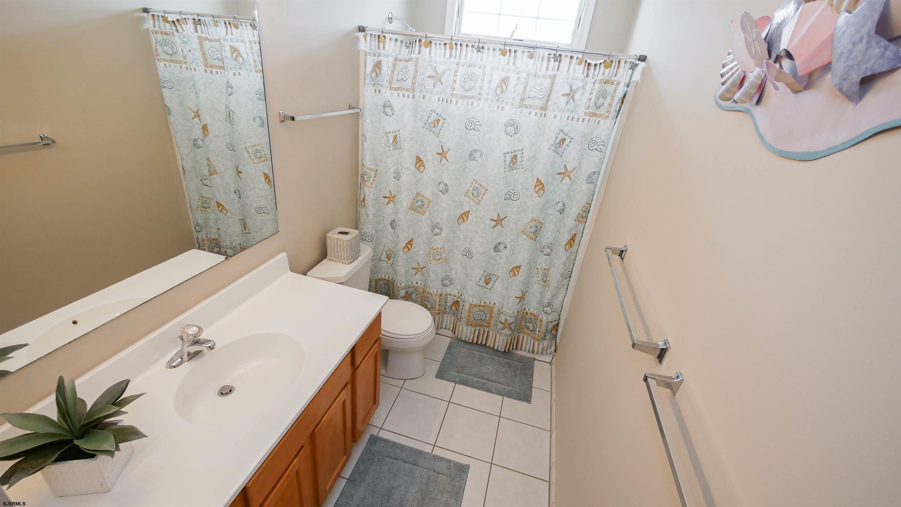 1910 Central Avenue, Unit B Ocean City, NJ 08226 - Photo 21 of 45 a bathroom with a white tub shower and sink