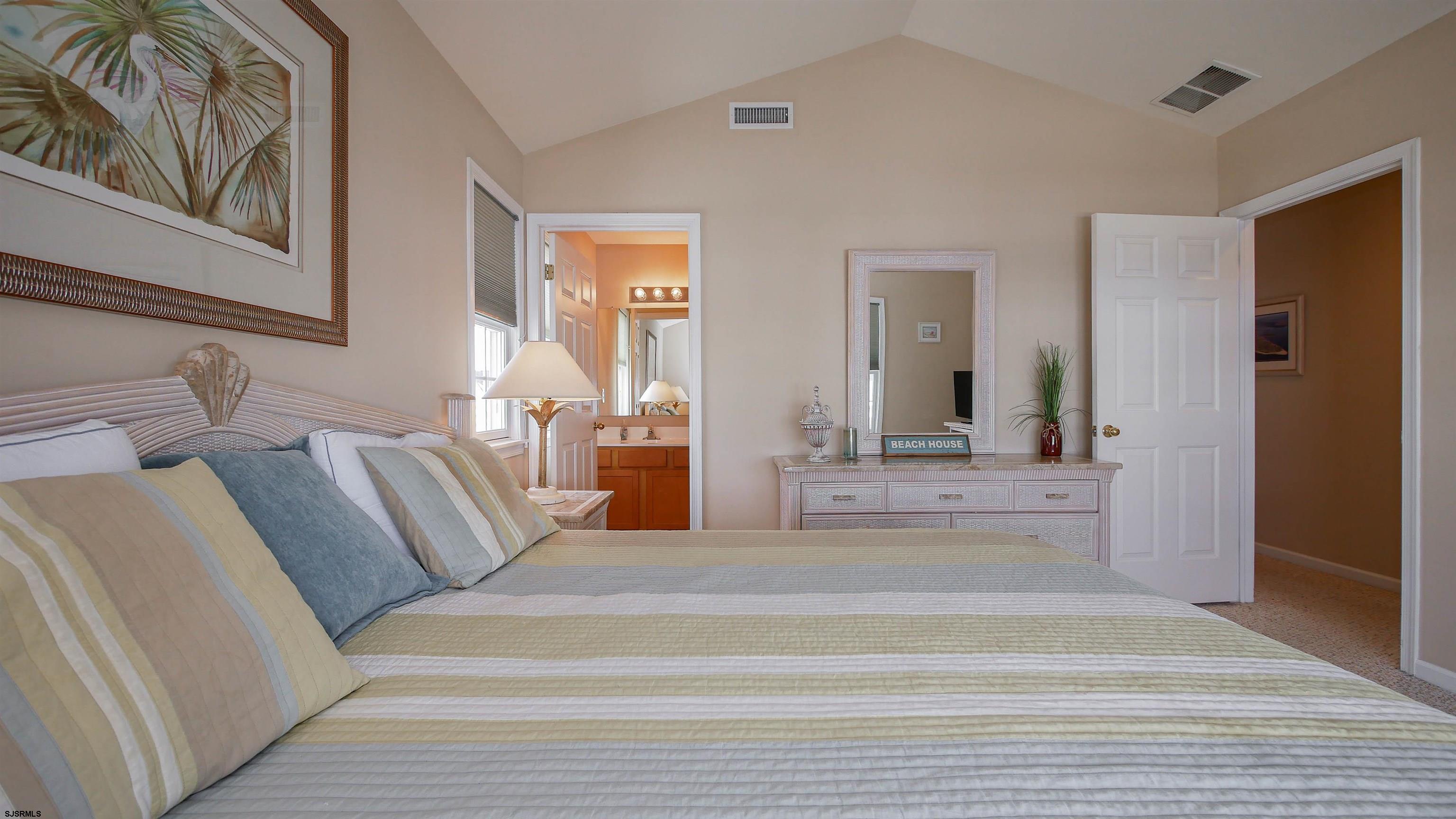 1910 Central Avenue, Unit B Ocean City, NJ 08226 - Photo 27 of 45 a spacious bedroom with a large bed and a mirror